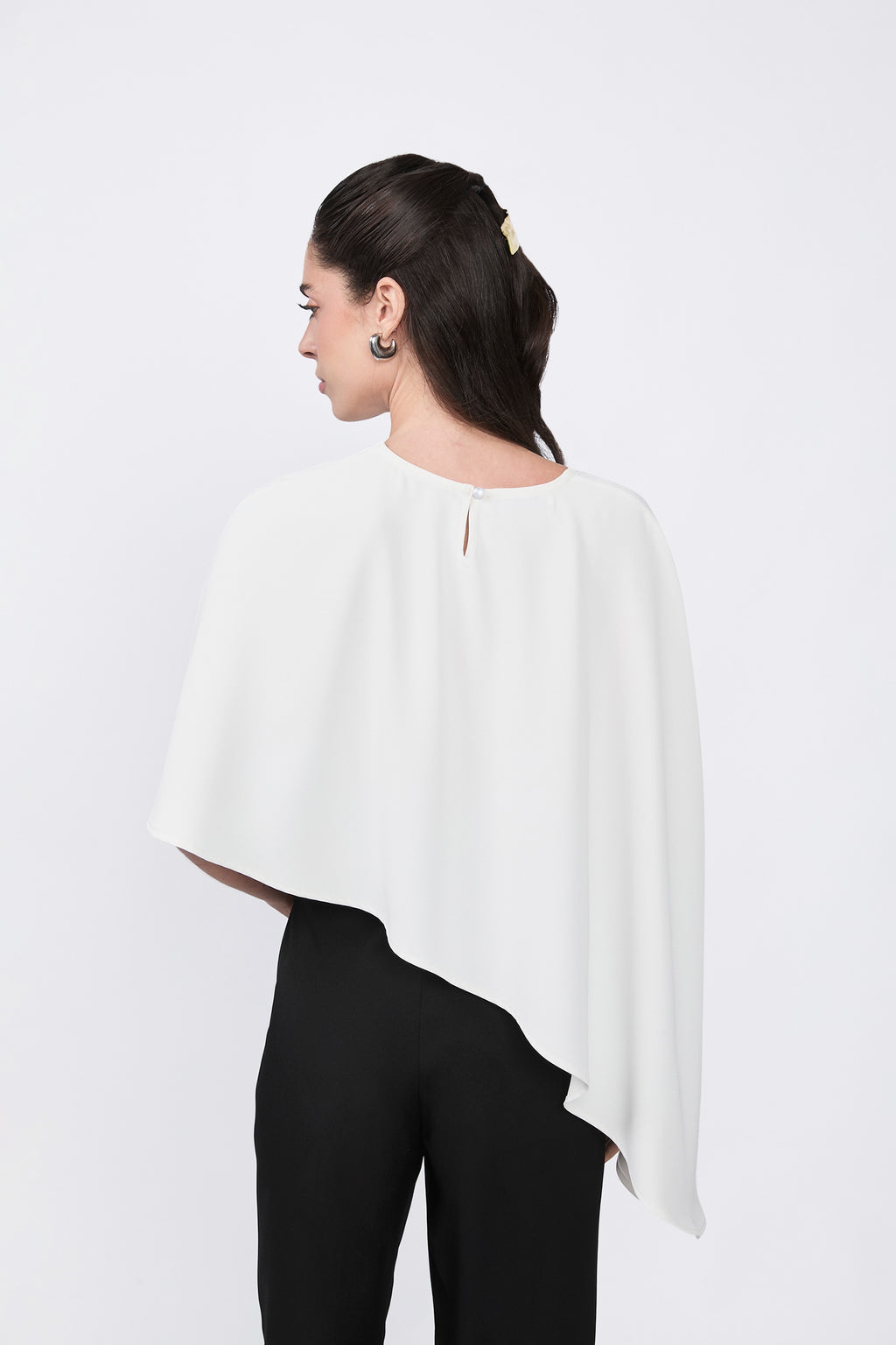 Asymmetrical Paris coat with decorative pearl button at the back.