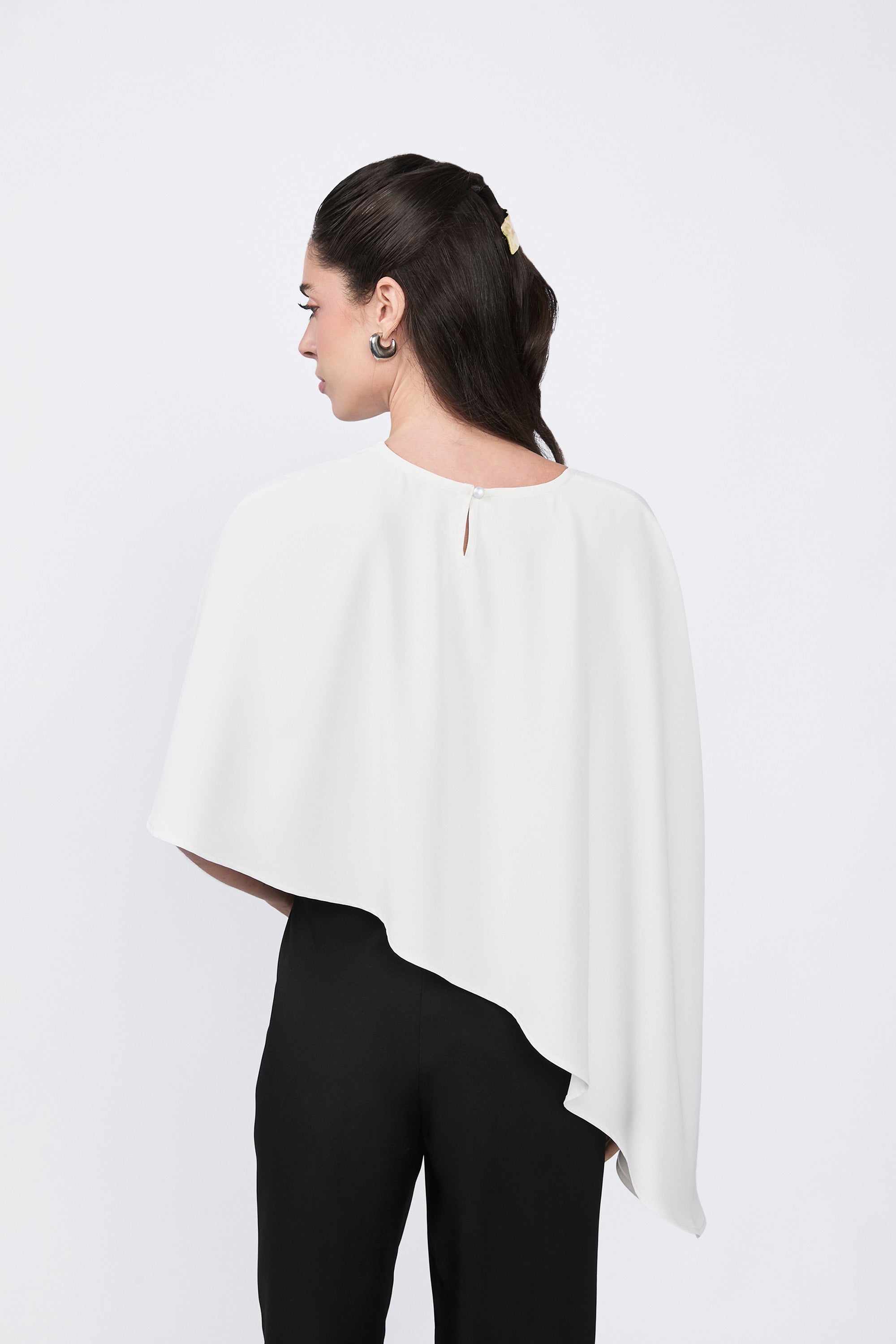 Asymmetrical Paris coat with decorative pearl button at the back.